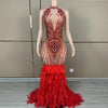 Luxury sleeveless prom dress with shining red rhinestones and a dramatic feather skirt. Ruby glamorous formal gown.