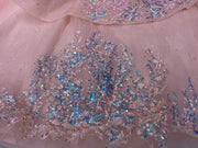 Pink quinceañera dress with corset bodice, illusion sleeves, and princess silhouette skirt.