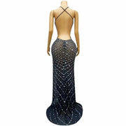 Elegant prom dress completely covered in silver rhinestones with a dramatic high split. Audre sparkling formal gown.
