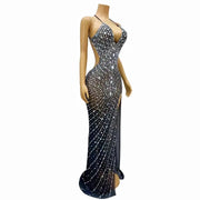 Elegant prom dress completely covered in silver rhinestones with a dramatic high split. Audre sparkling formal gown.