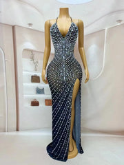 Elegant prom dress completely covered in silver rhinestones with a dramatic high split. Audre sparkling formal gown.