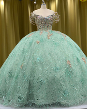 Mint green quinceañera dress with glitter tulle, star sparkle details, fitted bodice, and full skirt.