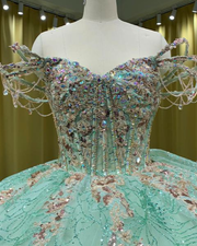 Mint green quinceañera dress with glitter tulle, star sparkle details, fitted bodice, and full skirt.