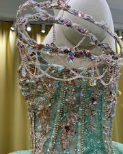 Mint green quinceañera dress with glitter tulle, star sparkle details, fitted bodice, and full skirt.