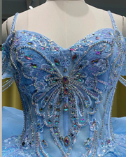 Light blue quinceañera gown with flowing princess-style skirt and fitted bodice.