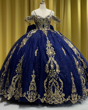Navy blue off-shoulder quinceañera dress with gold appliqués, crystal embellishments, and full princess skirt.