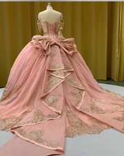 Strapless peach coral glitter quinceañera ball gown with ombre gold sequin appliqués.