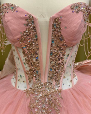 Strapless peach coral glitter quinceañera ball gown with ombre gold sequin appliqués.