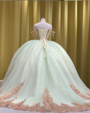Mint and rose gold quinceañera gown with tulle skirt, rose gold appliqués, and fitted bodice.