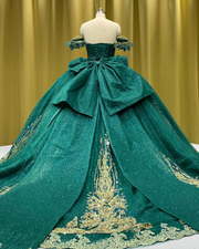 Emerald green off-shoulder princess quinceañera ball gown with corset bodice and full tulle skirt.