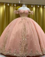 Blush pink quinceañera gown with gold beading, fitted bodice, and full princess skirt.
