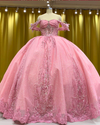Baby pink quinceañera gown with glitter details, lace trim, and full princess ball skirt.