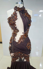 Deep brown mermaid gown with bronze baroque appliqués, asymmetrical cut-outs, and draped halter neckline