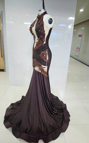 Deep brown mermaid gown with bronze baroque appliqués, asymmetrical cut-outs, and draped halter neckline