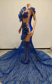 Royal blue mermaid gown featuring sculptural organza ruffles and a glittering mesh train, fitted silhouette with dramatic flare