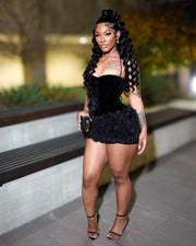 Woman Wearing a Luxury Black Velvet Mini Birthday Dress with Ruffled Hem and Sculpted Silhouette, Styled for Luxe Celebrations  
