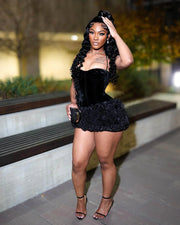 Woman Wearing a Luxury Black Velvet Mini Birthday Dress with Ruffled Hem and Sculpted Silhouette, Styled for Luxe Celebrations  